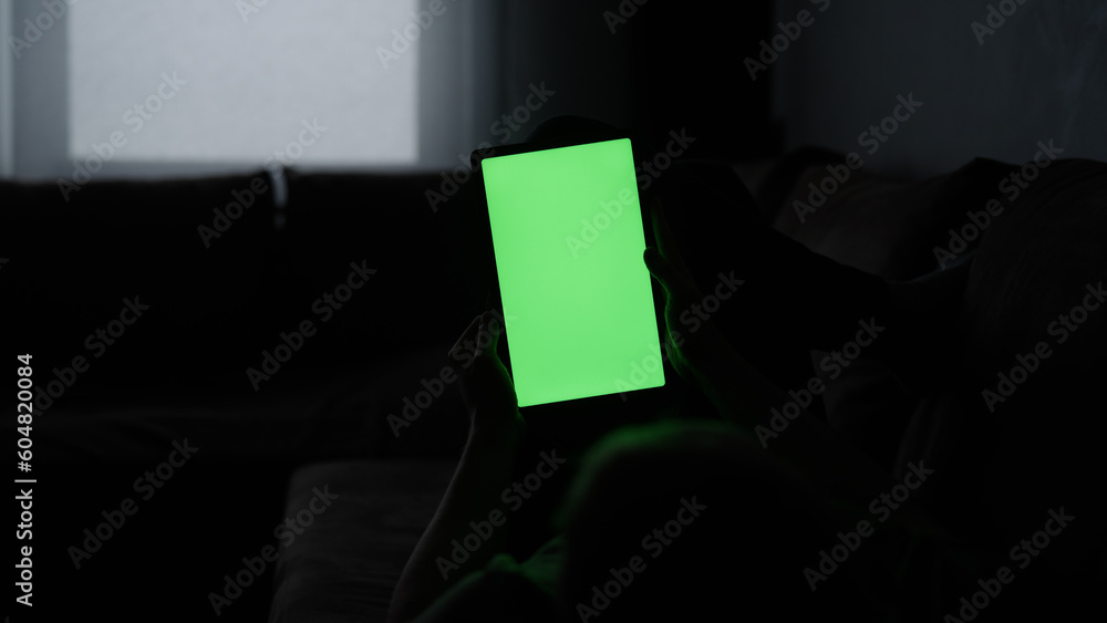 Naklejka premium Man at home lying on a couch with tablet pc with green screen