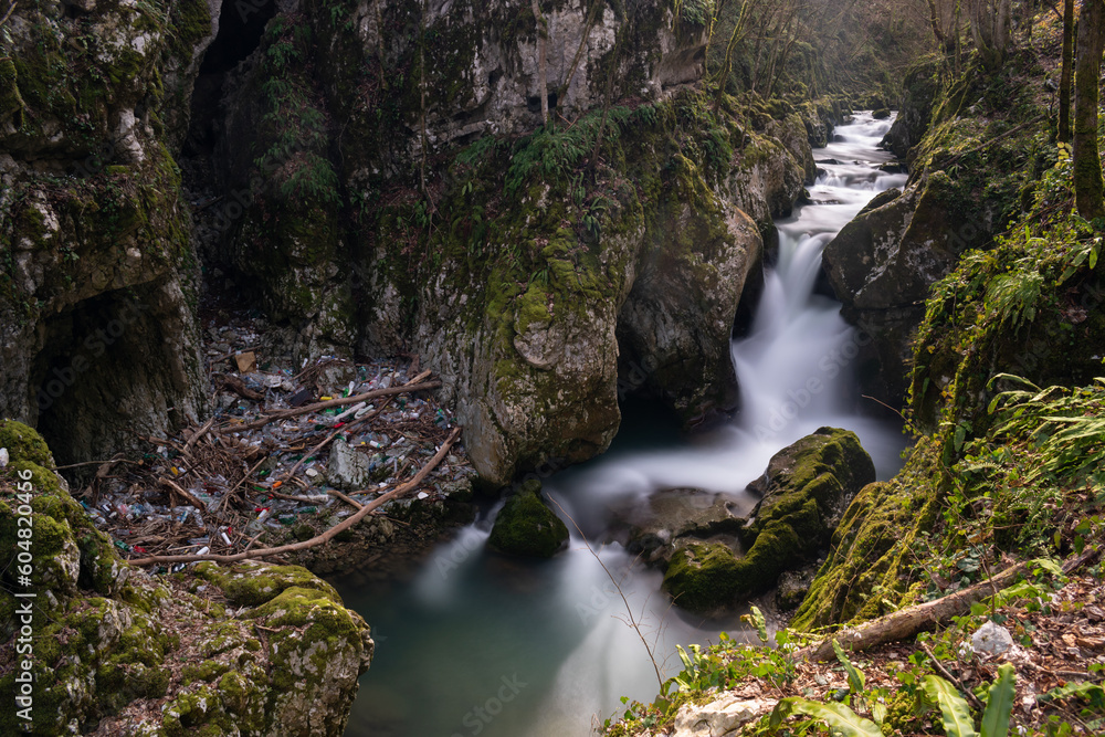 Waterfall with mossy rocks in mountain canyon and plastic waste problem, Svrakava river near Banja Luka Waterfall with mossy rocks in mountain canyon and plastic waste problem, Svrakava river near Banja Luka