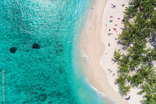 Aerial view of beautiful tropical beach turquoise ocean sea waters with shallow waves. Vibrant bright sunny day in summer. Coastal seascape. Vacation holiday sunny beach. Le Morne, Mauritius
