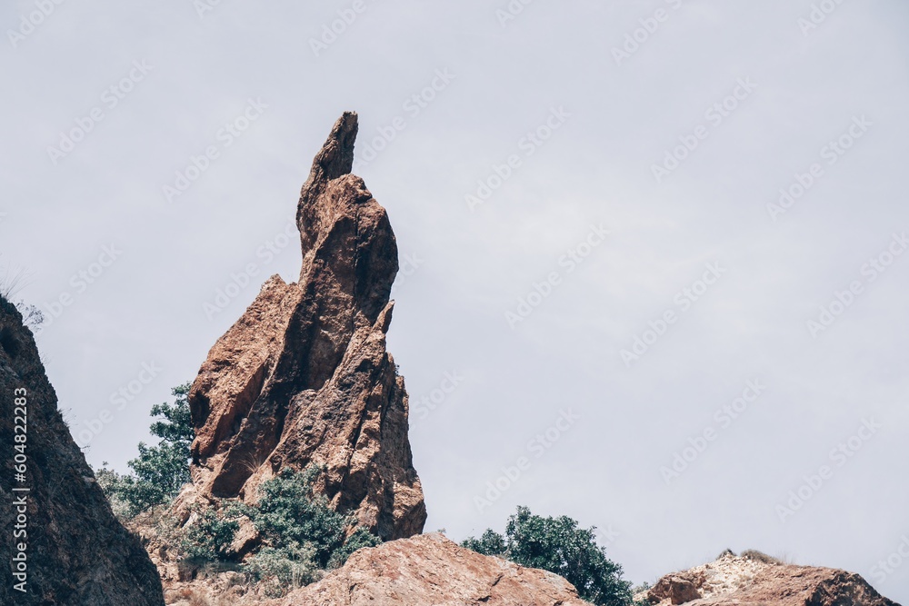 A close up of rocks that look like the beak of a bird or a sharp nose The picturesque volcanic coast of the island on the ocean waters - sharp rocks, dark stones A close up of rocks that look like the beak of a bird or a sharp nose The picturesque volcanic coast of the island on the ocean waters - sharp rocks, dark stones