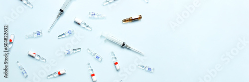Banner Pattern of ampoules and syringes. Vaccination. Bird flu. Covid 19. Flat lay ampoules and medicines on a blue background