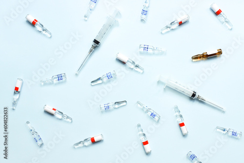 Pattern of ampoules and syringes. Vaccination. Bird flu. Covid 19. Flat lay ampoules and medicines on a blue background