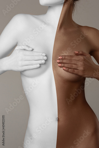 Faceless image of beautiful slim female body with tanned and white skin color against grey background. Female health care. Concept of body and skin care, spf protection, cosmetics, beauty