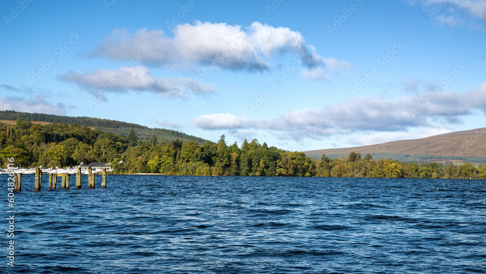 Loch Lomond on a summer day. View across the blue lake to the Scottish Highlands beyond. Scotland, UK.