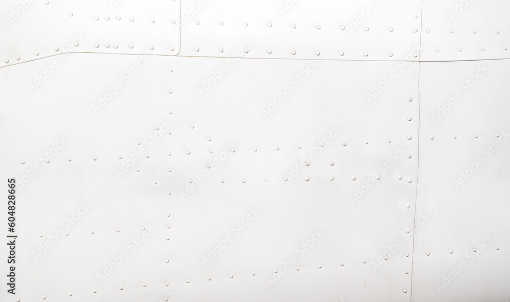 Silver metal surface of the aircraft fuselage with rivets. Fuselage