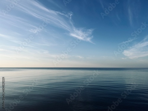 Blue sea horizon with some light clouds  seascape background