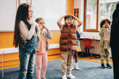 Foto Kids sing and move along to an educational rhyme in a classroom