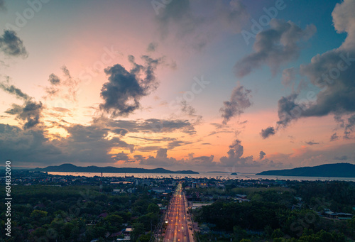 aerial view colorful sky at sunrise above the main road..aerial view scenery light through to sky above Chalong gulf..amazing sky of bright sunrise in nature and travel concept