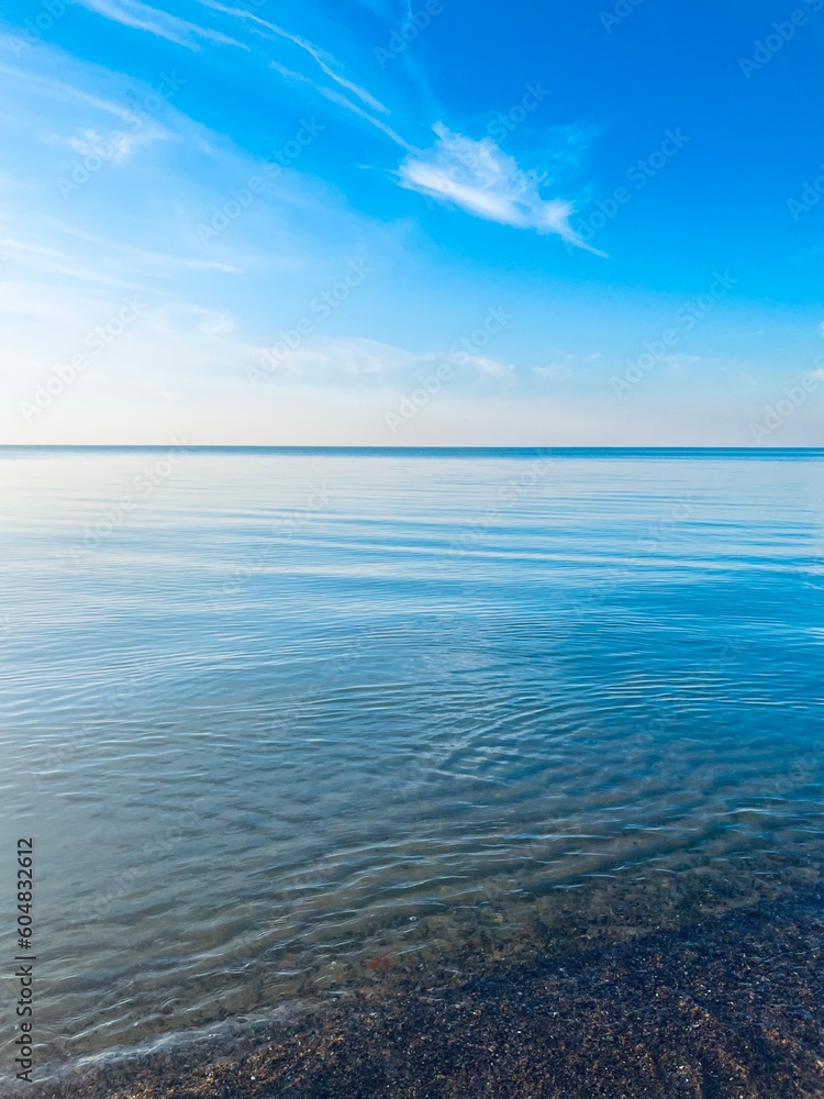 Blue sea horizon with some light clouds, seascape background