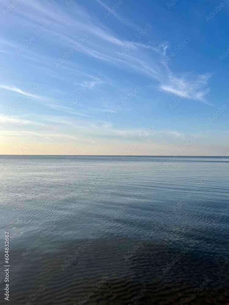 Blue sea horizon with some light clouds, seascape background