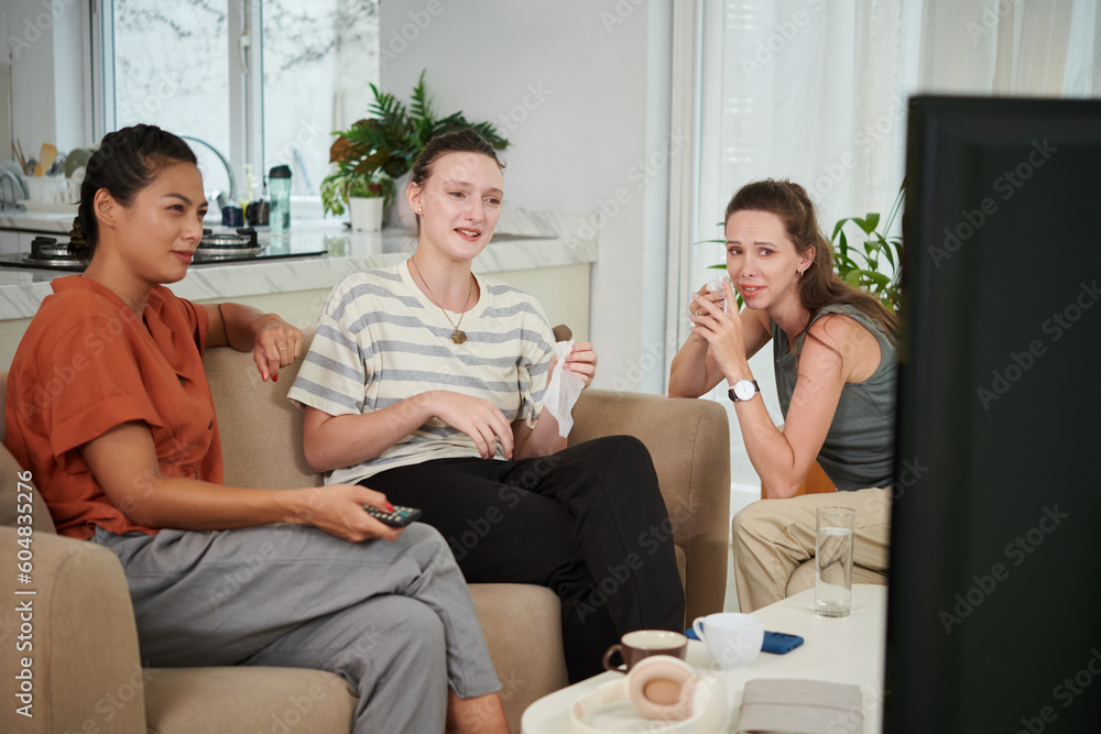 Group of friends laughing and crying when watching comedy movie on tv Group of friends laughing and crying when watching comedy movie on tv