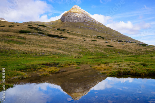 Mountain peak in the sun in summer. Mountain landscape that reflects in the river