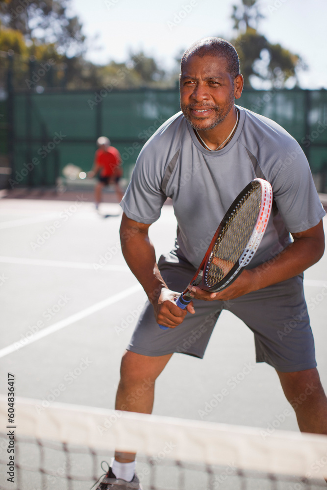 Older man playing tennis on court - obrazy, fototapety, plakaty 
