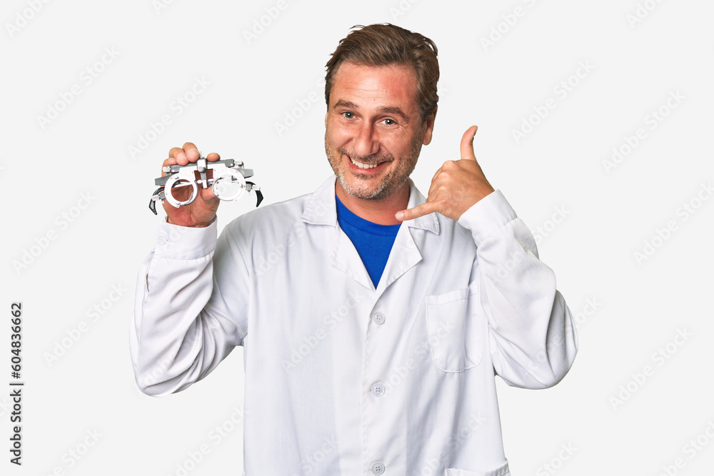 A middle-aged optometrist man showing a mobile phone call gesture with fingers. A middle-aged optometrist man showing a mobile phone call gesture with fingers.