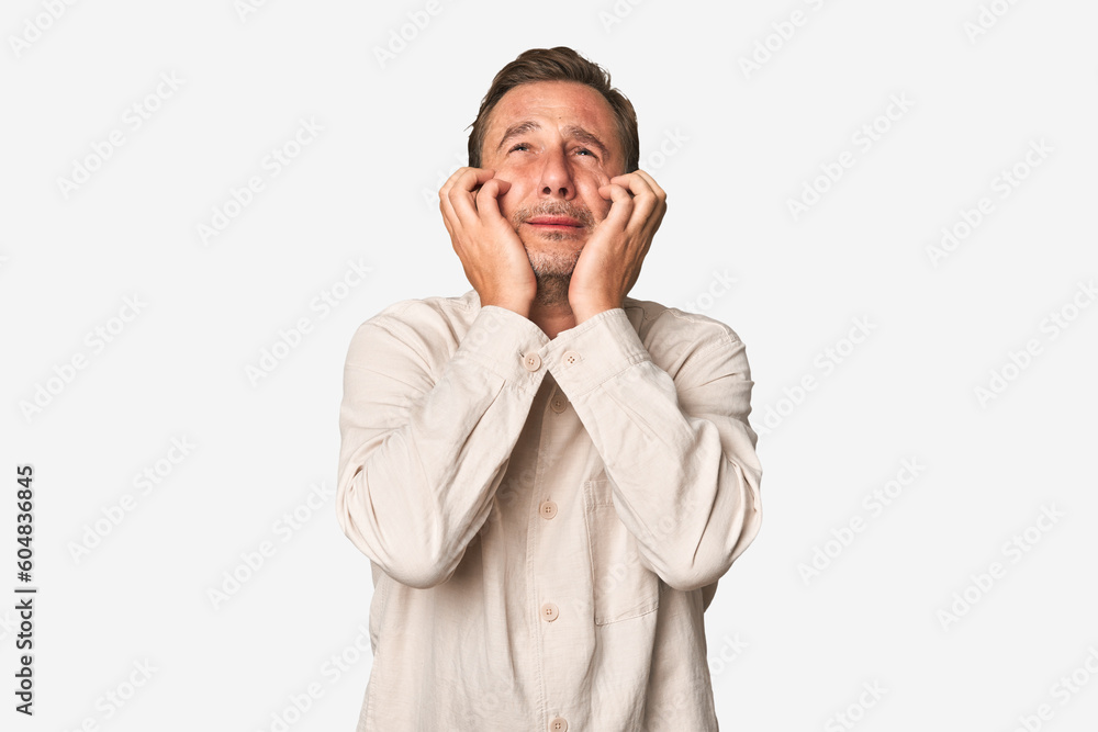 A middle-aged man isolated crying, unhappy with something, agony and confusion concept. A middle-aged man isolated crying, unhappy with something, agony and confusion concept.