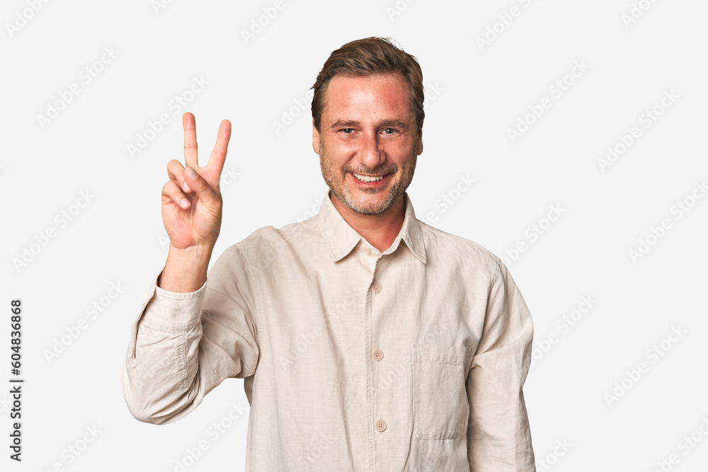 A middle-aged man isolated joyful and carefree showing a peace symbol with fingers. A middle-aged man isolated joyful and carefree showing a peace symbol with fingers.