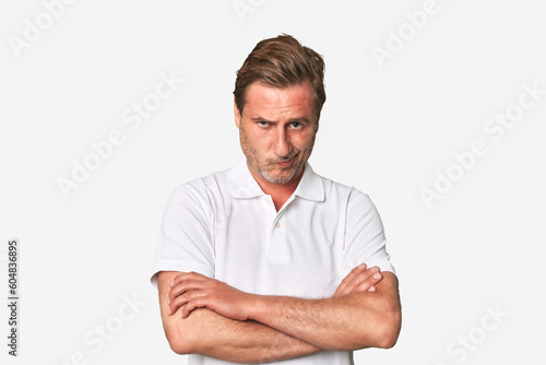 Canvas Print A middle-aged man isolated frowning face in displeasure, keeps arms folded