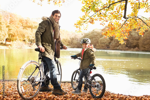 Father and son sitting on bicycles in park