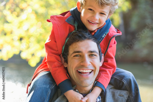 Photographie Father carrying son on shoulders in park