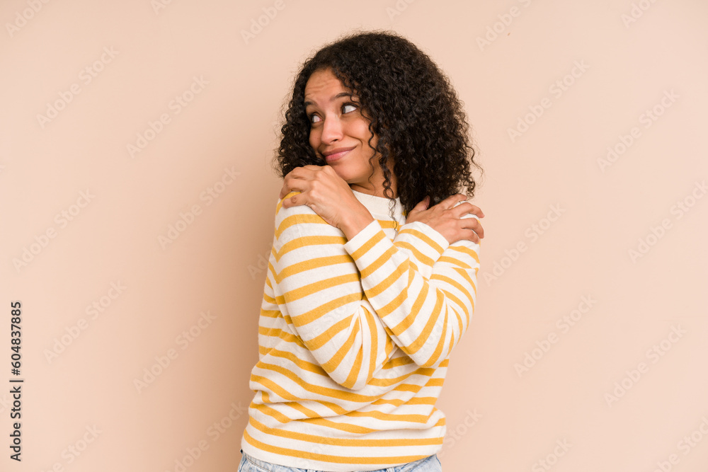 Young african american curly woman isolated hugs, smiling carefree and happy. Young african american curly woman isolated hugs, smiling carefree and happy.