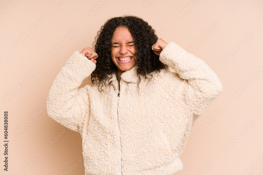 Young african american curly woman isolated raising fist after a victory, winner concept. Young african american curly woman isolated raising fist after a victory, winner concept.