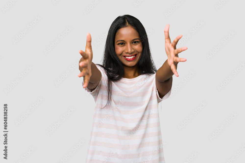 Young Indian woman cut out isolated on white background feels confident giving a hug to the camera. Young Indian woman cut out isolated on white background feels confident giving a hug to the camera.