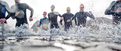 Canvas Print Triathletes emerging from water