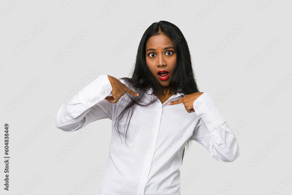 Young Indian woman cut out isolated on white background surprised pointing with finger, smiling broadly. Young Indian woman cut out isolated on white background surprised pointing with finger, smiling broadly.