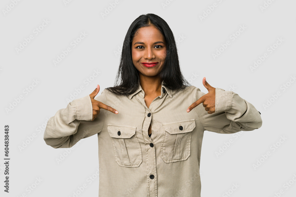 Young Indian woman cut out isolated on white background person pointing by hand to a shirt copy space, proud and confident Young Indian woman cut out isolated on white background person pointing by hand to a shirt copy space, proud and confident