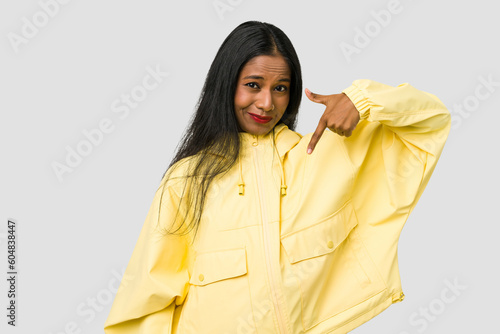 Young Indian woman cut out isolated on white background person pointing by hand to a shirt copy space, proud and confident © Asier