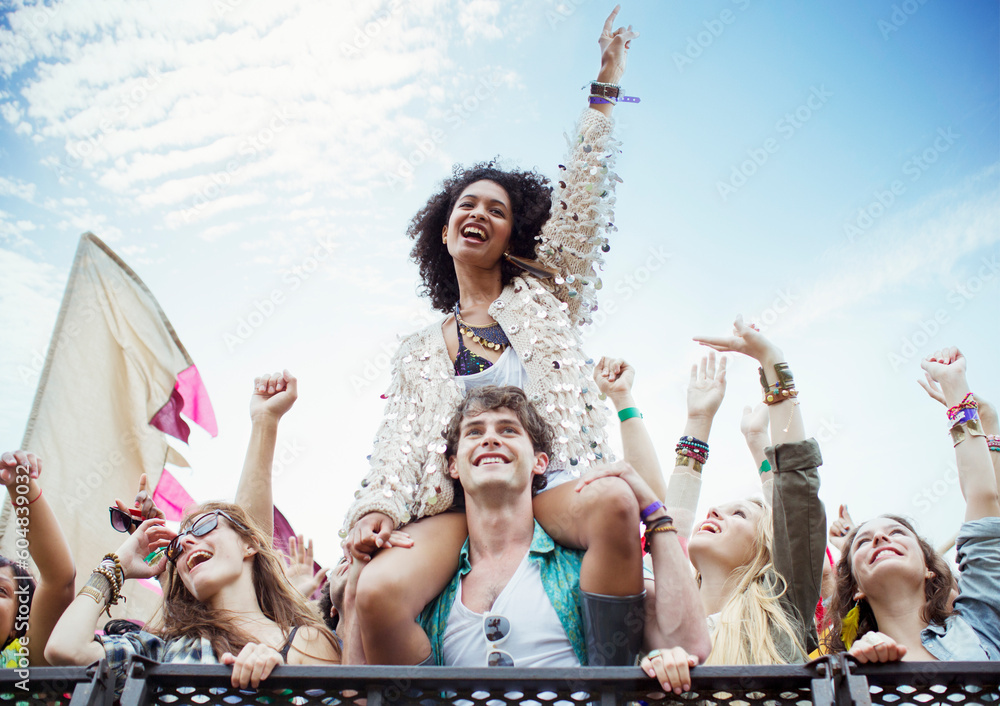 © KOTO - Cheering woman on man shoulders at music festival © KOTO - Cheering woman on man shoulders at music festival