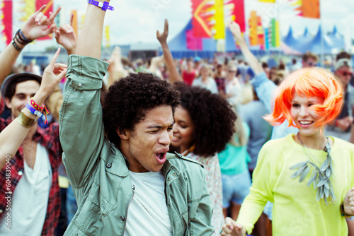Friends dancing and cheering at music festival
