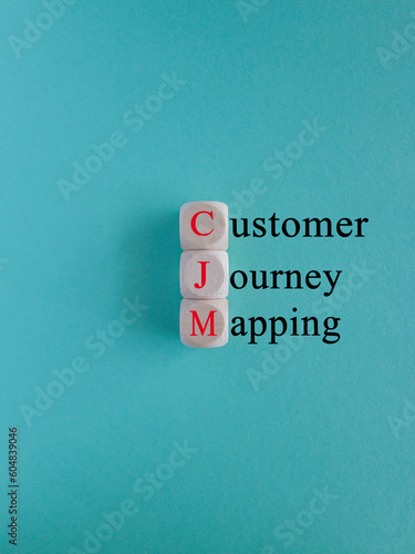 CJM customer journey mapping symbol. Concept red words CJM customer journey mapping on wooden cubes on a beautiful light blue background. Business and CJM customer journey mapping concept. Copy space. photo