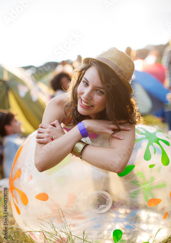 Portrait happy woman leaning on inflatable chair outside tents at music festival