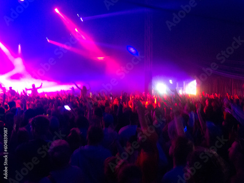 Crowd facing illuminated stage