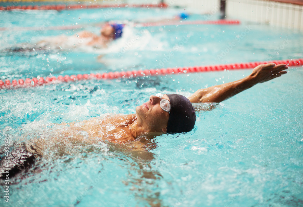 Swimmers racing in backstroke in pool