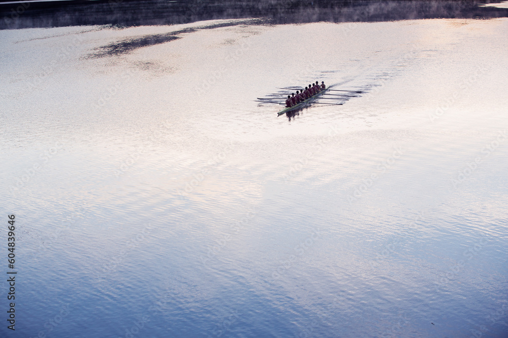 Fototapeta premium Rowing crew rowing scull on lake in distance