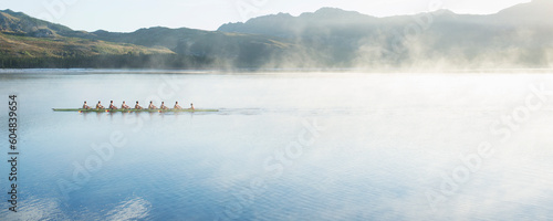 Fotografija Rowing team rowing scull on lake