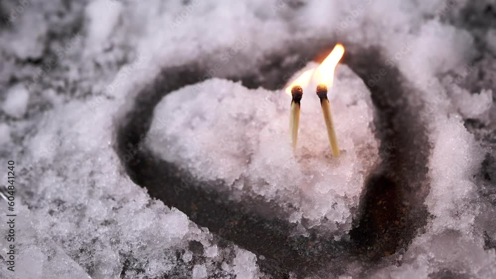 Two Burning Matches are Burning on an Island of Wet Snow in Shape of a