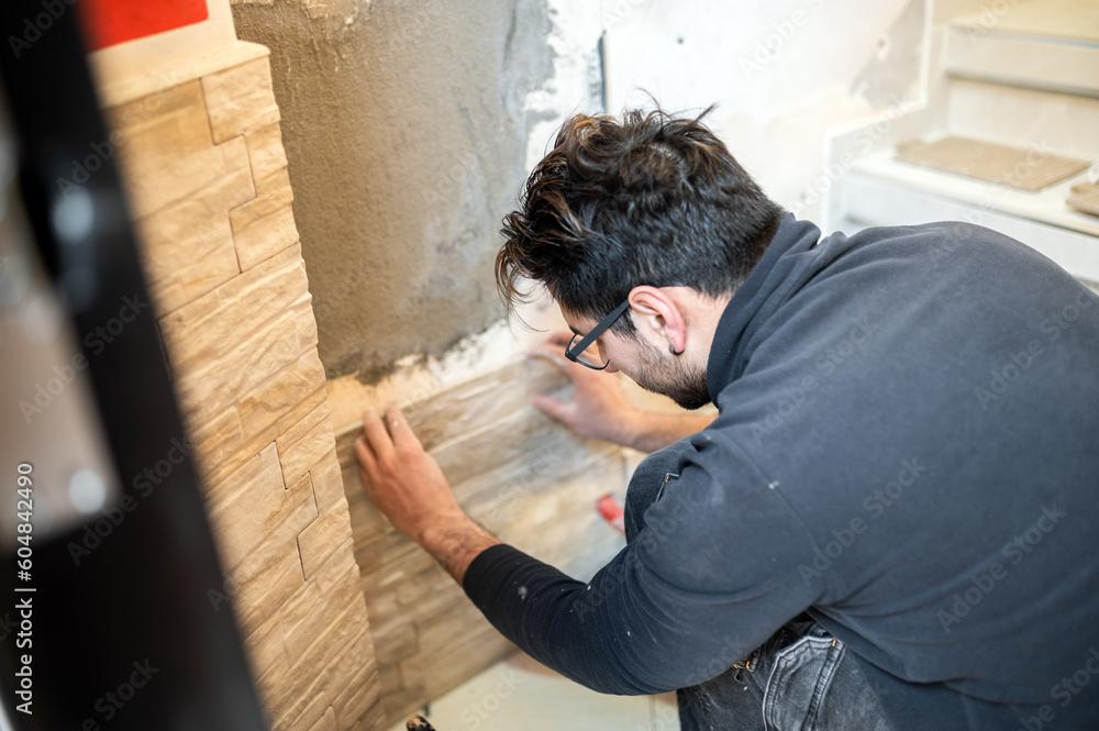 Obraz premium Closeup of a tiler applying tiles to a wall