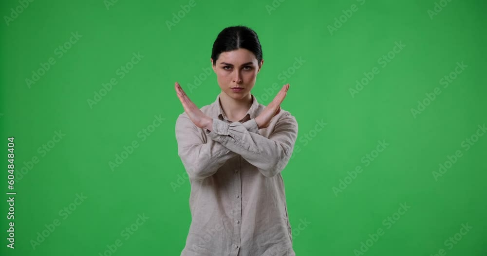 Caucasian woman stands with her arms crossed in front of her chest, conveying a clear message of disagreement or refusal. The gesture can indicate a variety of negative emotions. Caucasian woman stands with her arms crossed in front of her chest, conveying a clear message of disagreement or refusal. The gesture can indicate a variety of negative emotions.