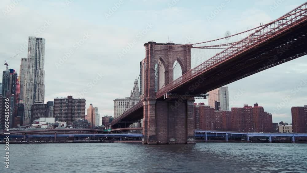 Modern skyline of Lower Manhattan from a moving boat under Brooklyn Bridge, New York City in slow motion Modern skyline of Lower Manhattan from a moving boat under Brooklyn Bridge, New York City in slow motion