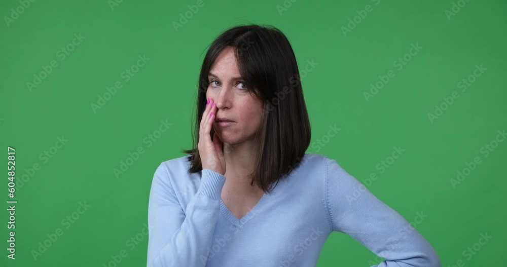 A Caucasian woman standing on a green screen background looks frustrated and disappointed. She facepalms in disbelief, expressing her dissatisfaction with what she has just seen or heard. A Caucasian woman standing on a green screen background looks frustrated and disappointed. She facepalms in disbelief, expressing her dissatisfaction with what she has just seen or heard.