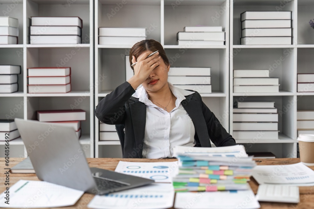 Asian business women are stressed while working on laptop and pile of documents, Tired asian businesswoman with headache at office, feeling sick at work Asian business women are stressed while working on laptop and pile of documents, Tired asian businesswoman with headache at office, feeling sick at work