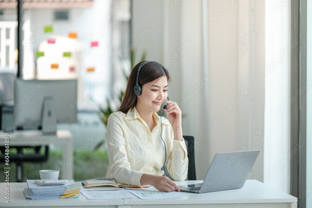 Portrait of happy smiling female customer support phone operator at workplace. Asian Portrait of happy smiling female customer support phone operator at workplace. Asian
