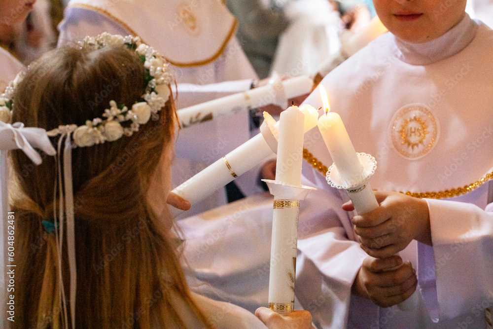 Obraz na płótnie children distribute fire from candles of peace candles to other candles at first communion w salonie