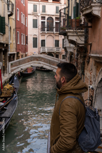 Young male tourist looking towards the canals of Venice with gondolas © Jenni Ventura Martil