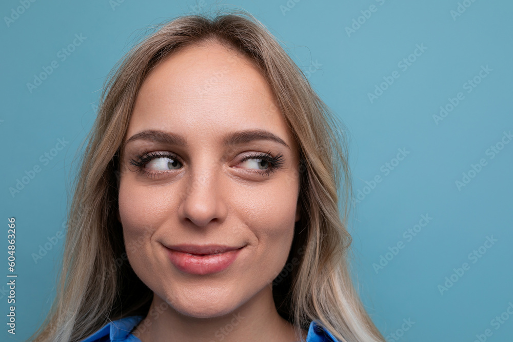 photo of adorable casual young woman with smiling eyes on blue background photo of adorable casual young woman with smiling eyes on blue background
