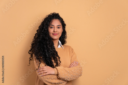 portrait of black woman with arms crossed in beige background. portrait, real people concept.