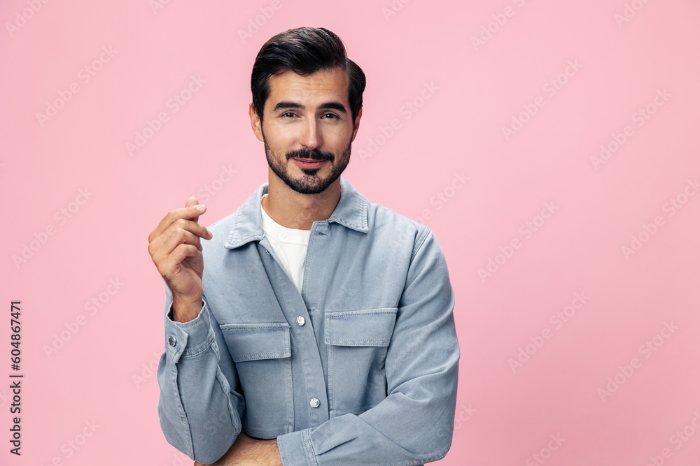 Stylish brunette man with a beard looks into the camera on a pink background in a white T-shirt and jeans smile and joyful emotion on his face, copy space Stylish brunette man with a beard looks into the camera on a pink background in a white T-shirt and jeans smile and joyful emotion on his face, copy space